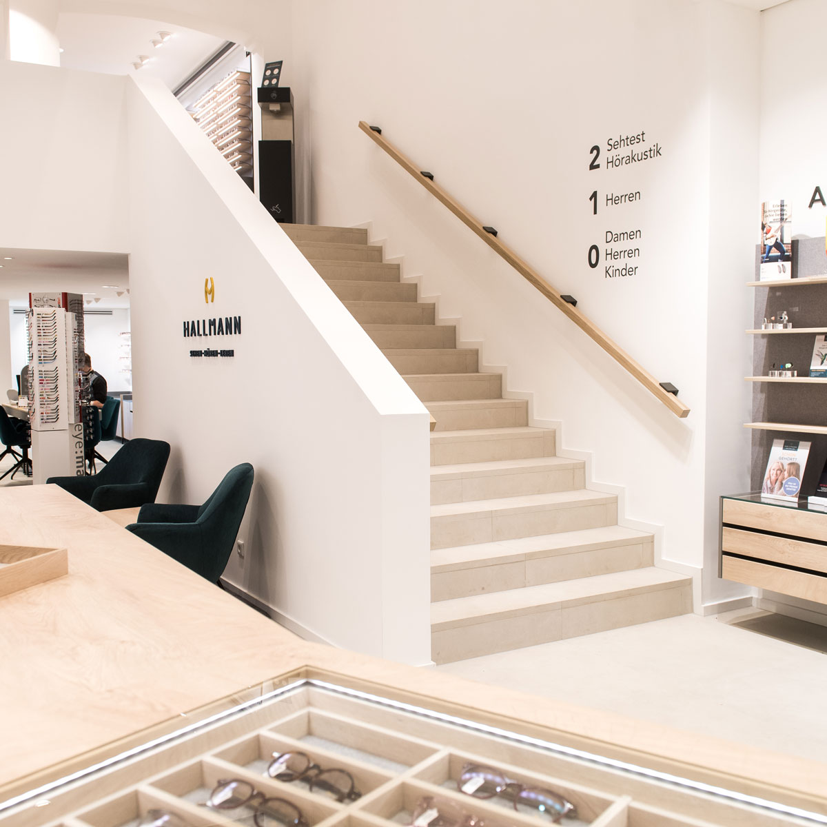 Optiker Ladenbau mit Treppe und integrierter Brillenpräsentation im modernen Optikergeschäft