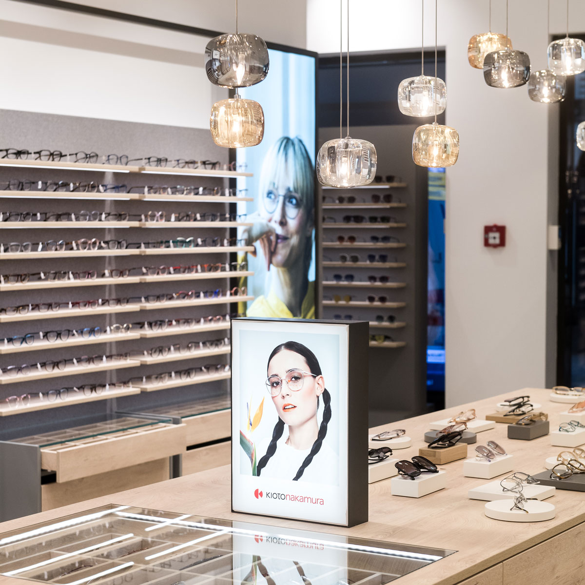 Verkaufstisch mit Brillen und Spiegel im modernen Optikergeschäft