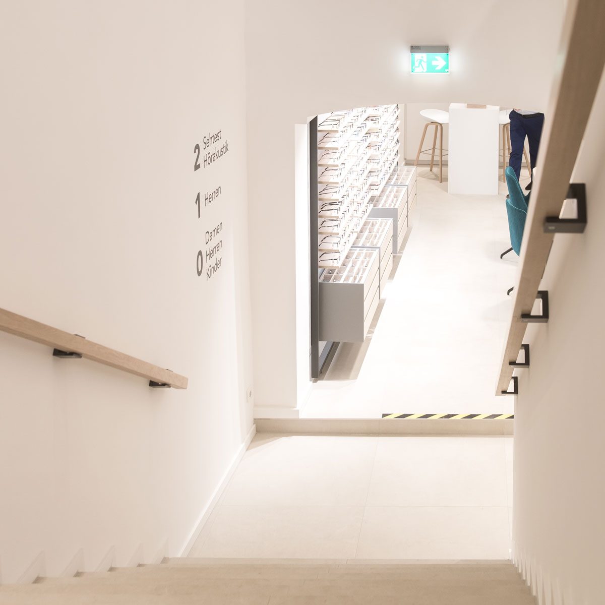 Treppenaufgang im modernen Optikergeschäft mit minimalistischem Ladenbau